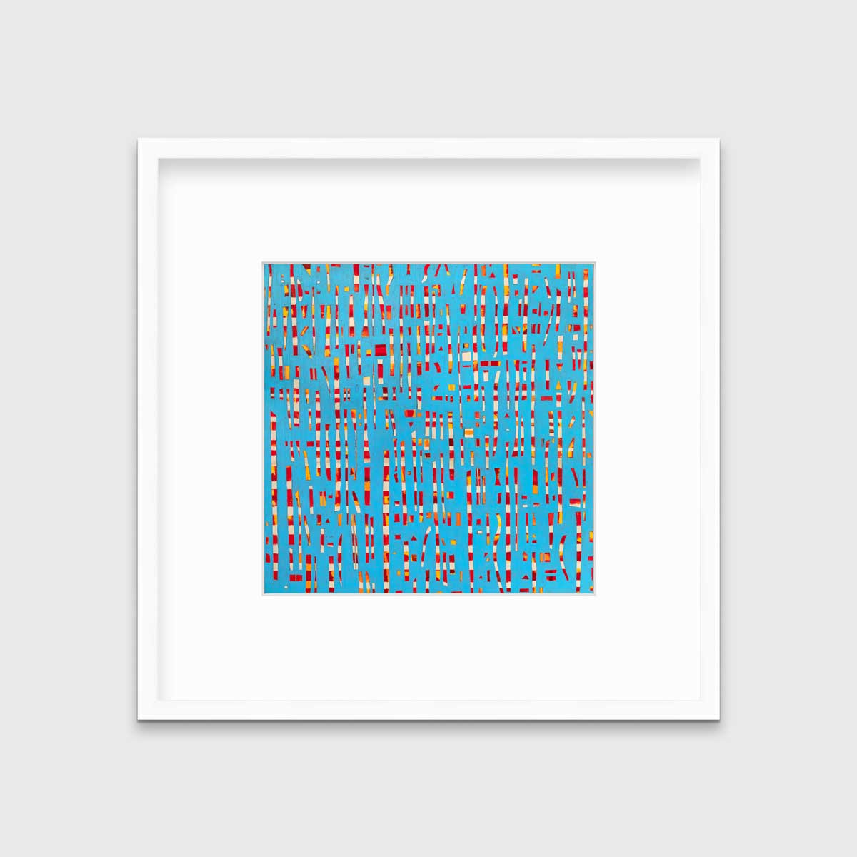 A blue, red, yellow and white abstract print in a white frame with a mat hangs on a white wall.