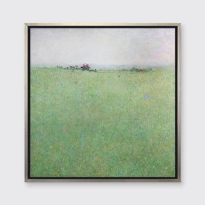 A green abstract landscape print in a silver floater frame hangs on a white wall.