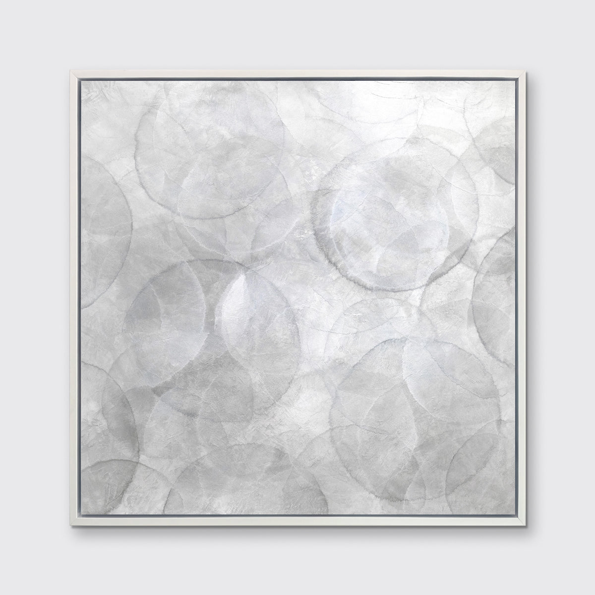 A grey and white abstract geometric print in a white floater frame hangs on a white wall.