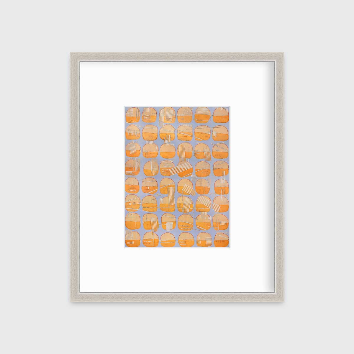 A orange and light purple abstract circle print in a silver frame with a mat hangs on a white wall.