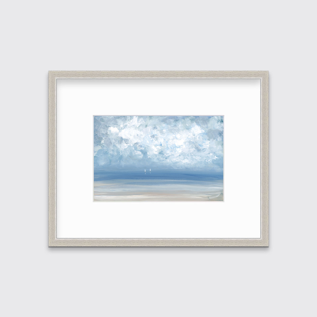 A white, blue and beige abstract seascape print in a silver frame with a mat hangs on a white wall.