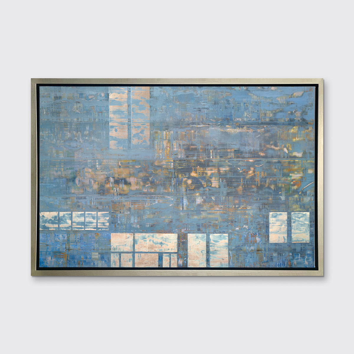 A blue and grey geometric abstract print in a silver floater frame hangs on a white wall.
