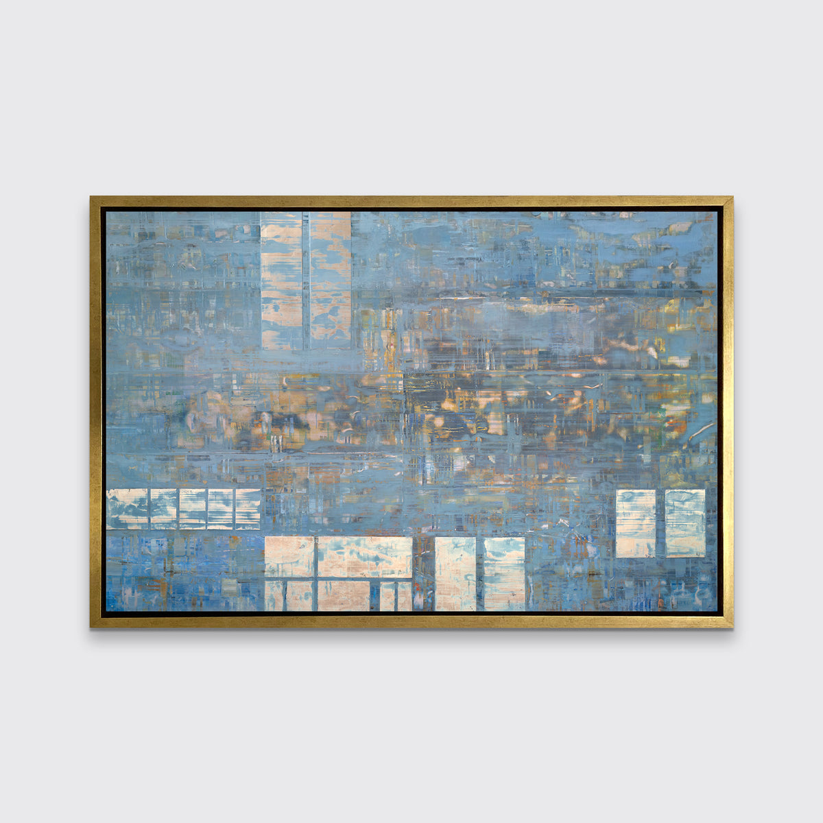 A blue and grey geometric abstract print in a gold floater frame hangs on a white wall.