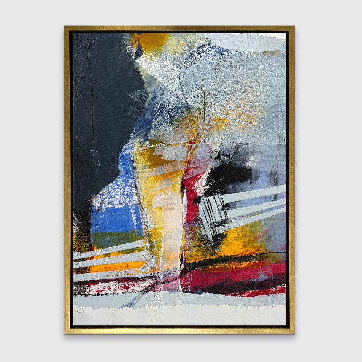 A white, yellow, red and grey abstract print in a gold floater frame hangs on a white wall.