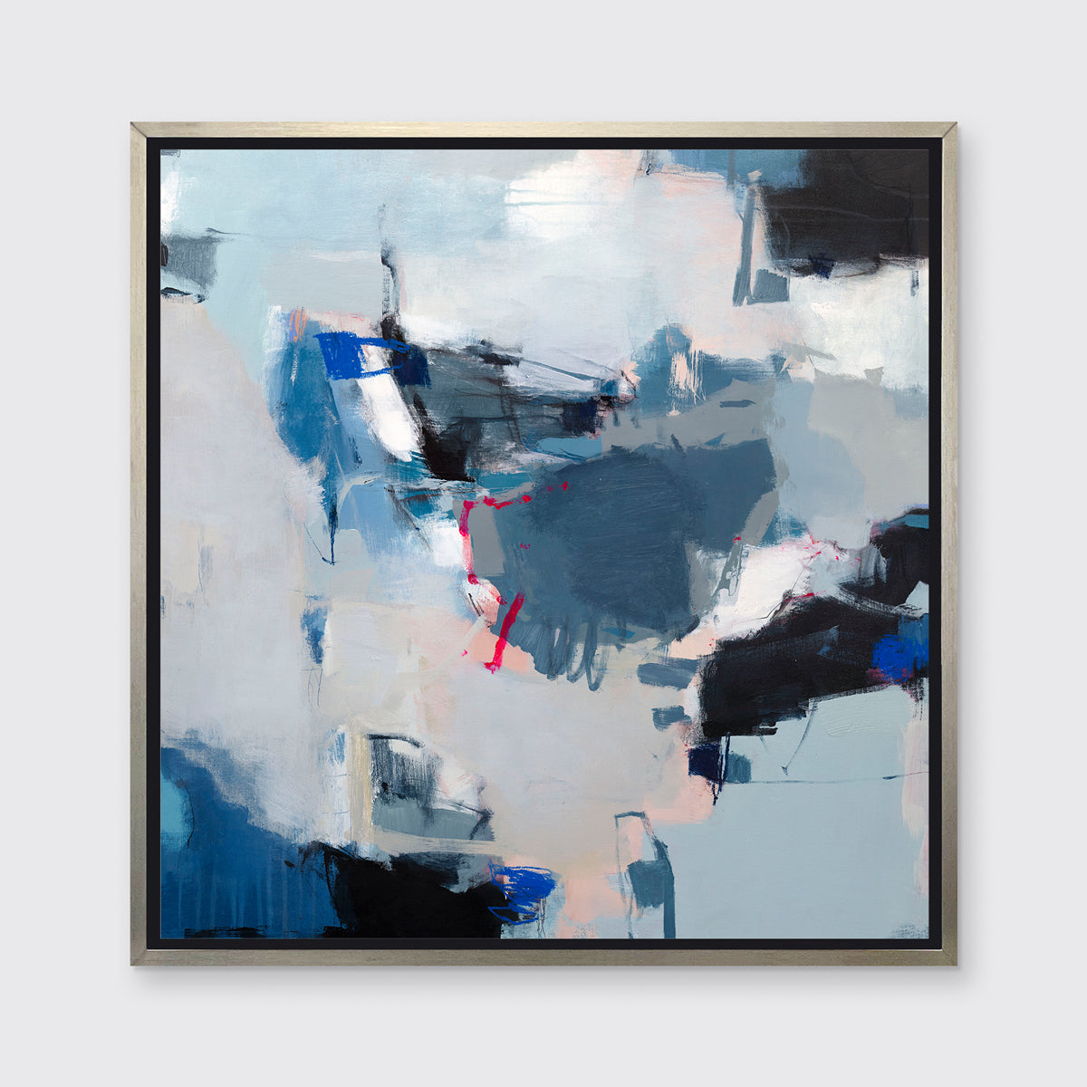 A blue, white and black abstract print in a silver floater frame hangs on a white wall.