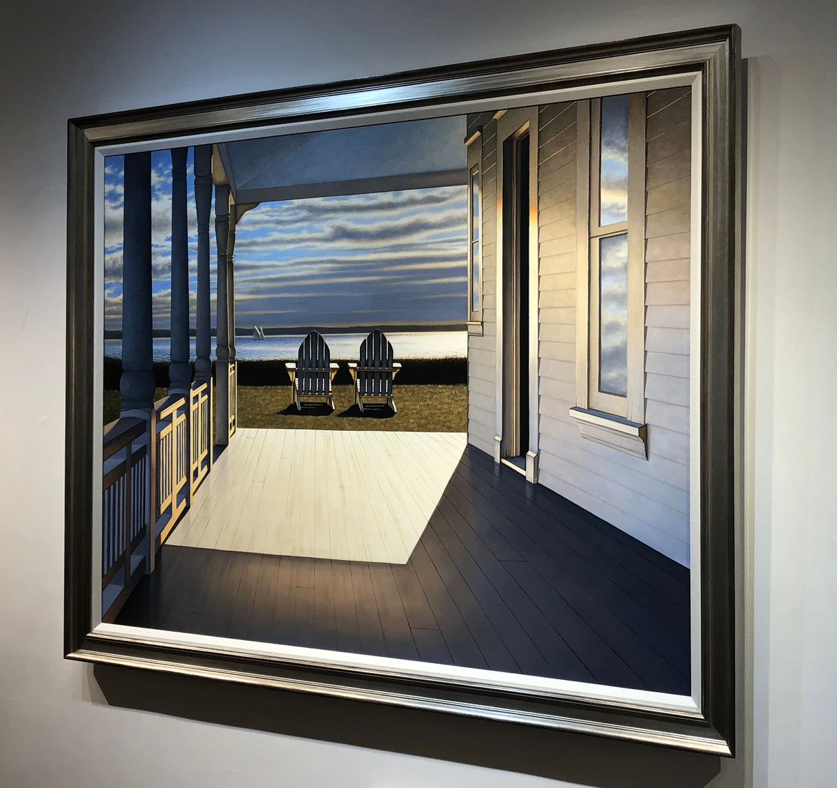 A photo of Daniel Pollera's "Passing Time" in a silver frame, and hung on a white wall taken from right side.