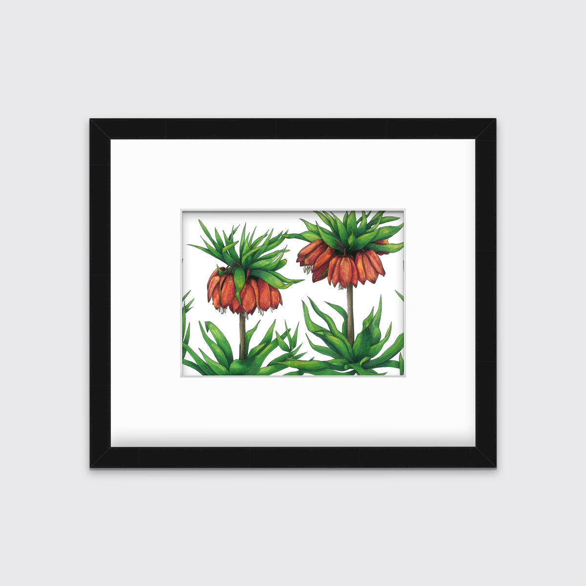 A green and red-orange floral print in a black frame with a mat hangs on a white wall.