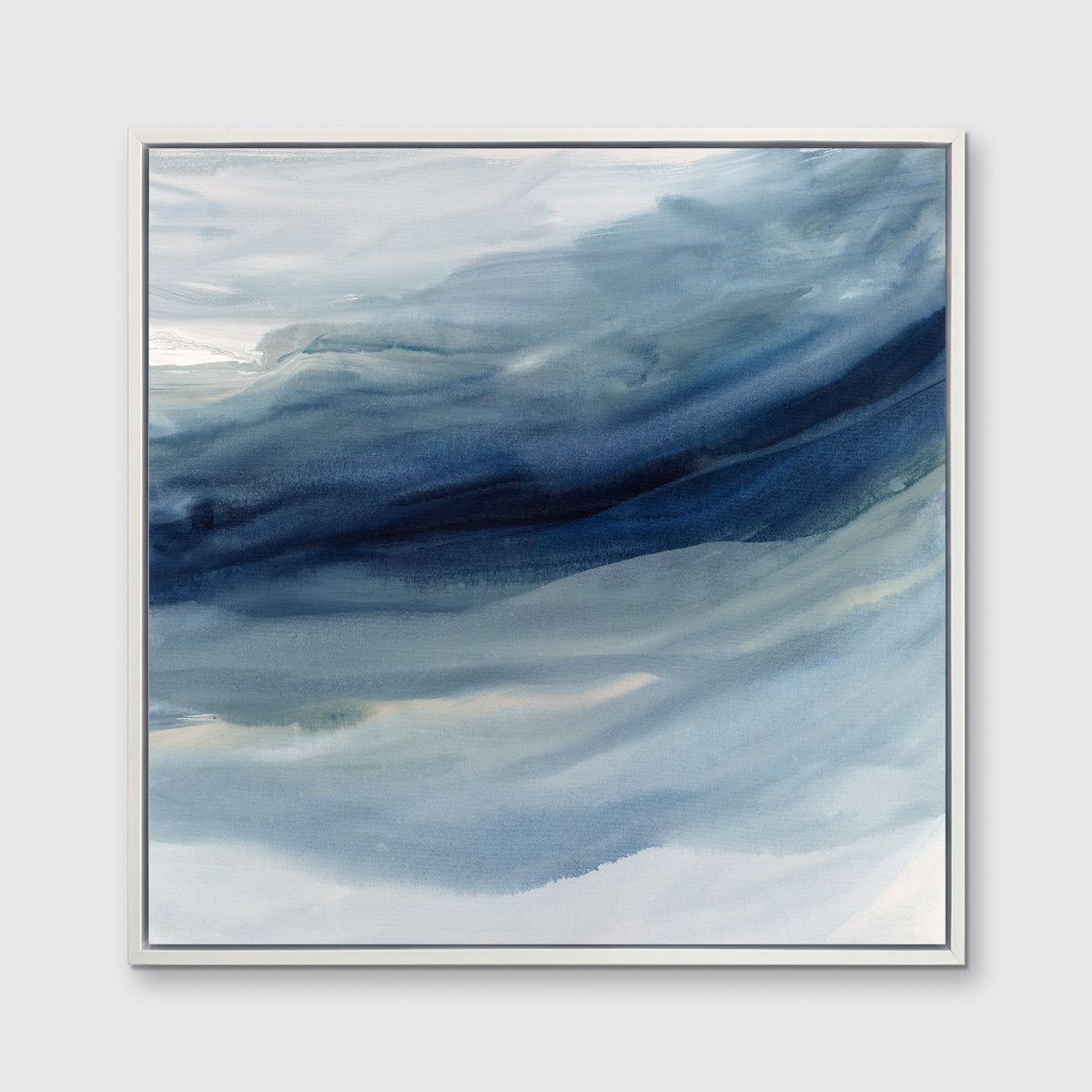 A blue, navy and white abstract print in a white floater frame hangs on a white wall.