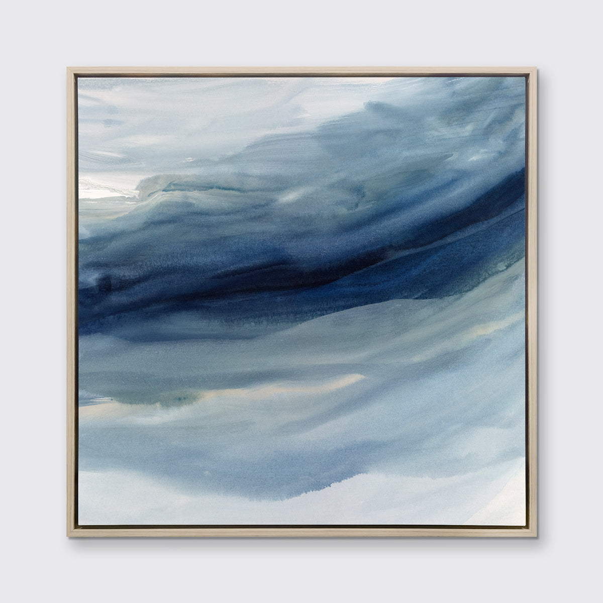 A blue, navy and white abstract print in a white oak wood floater frame hangs on a white wall.