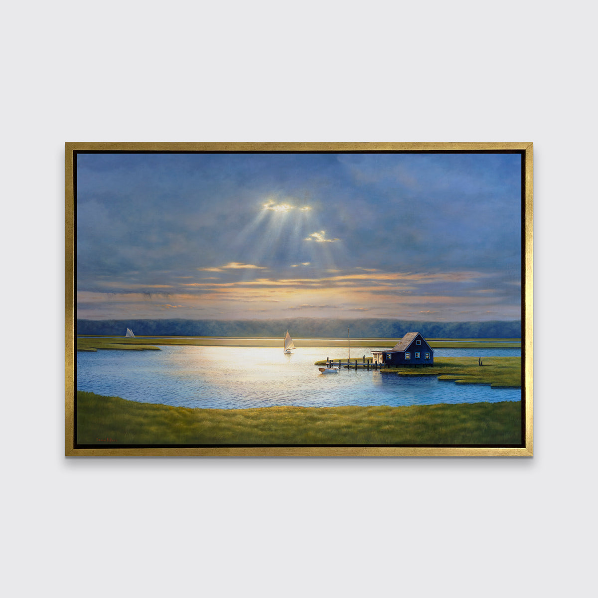 A realist coastal print in a gold floater frame hangs on a white wall.