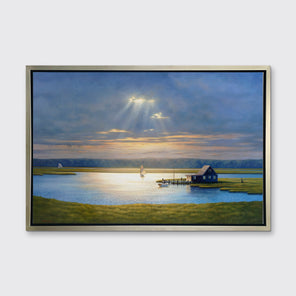 A realist coastal print in a silver floater frame hangs on a white wall.