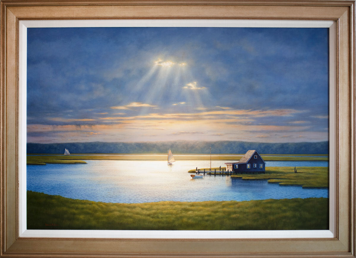 A painting of a bay house with sailboats, framed in a gold frame with a linen lining.