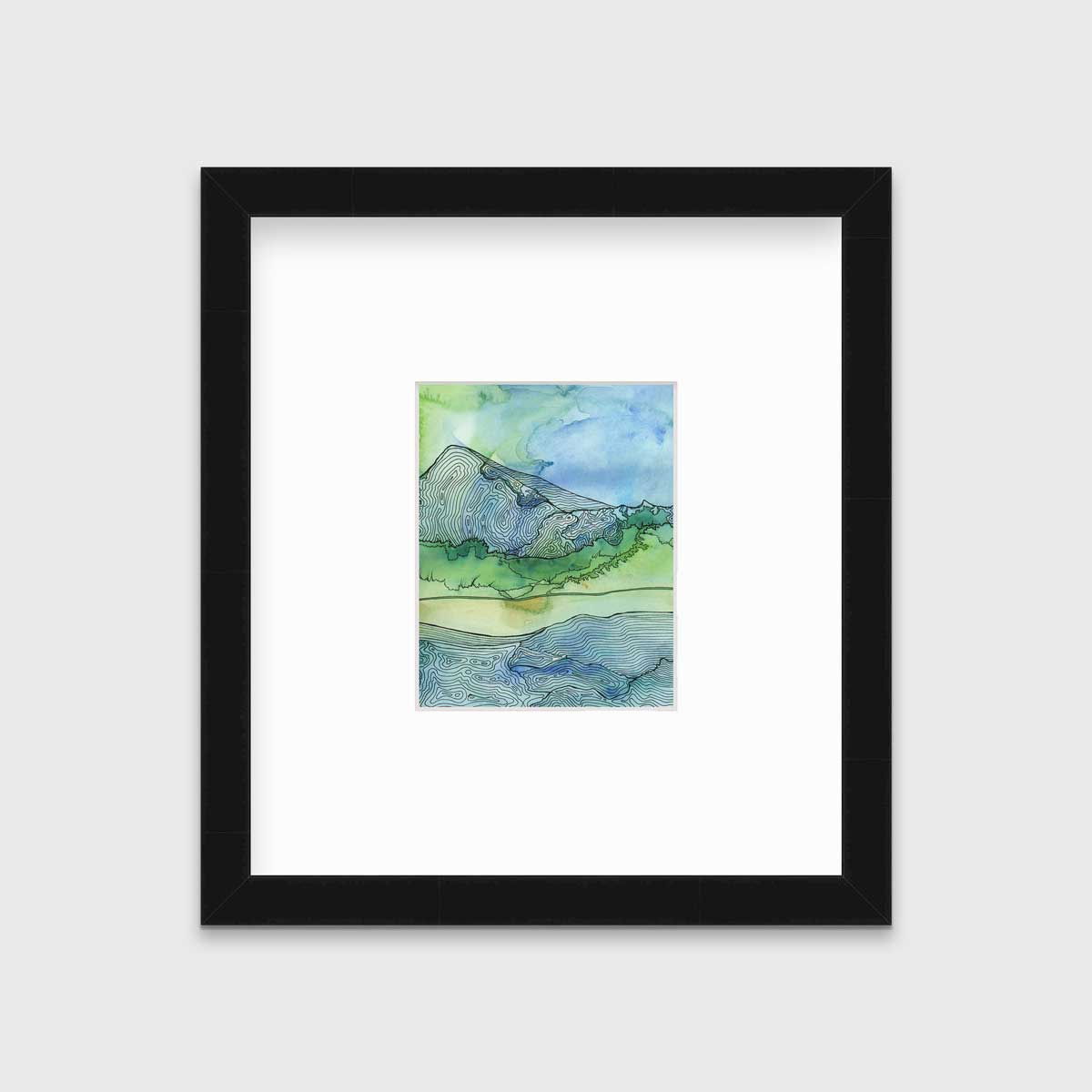 A blue and green landscape illustration print framed in a black frame with a mat hangs on a light grey wall.