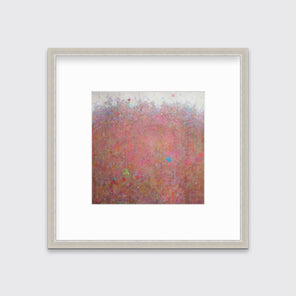 A red abstract landscape print in a silver frame with a mat hangs on a white wall.
