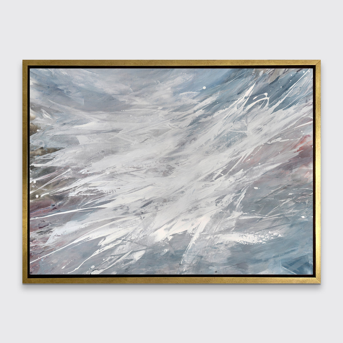A grey, white and blue abstract print in a gold floater frame hangs on a white wall.