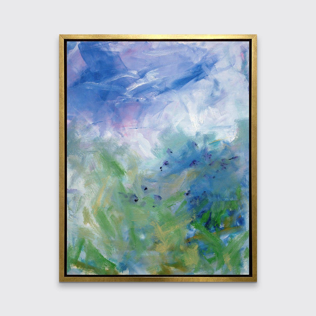 A blue, purple and green abstract print in a gold floater frame hangs on a white wall.