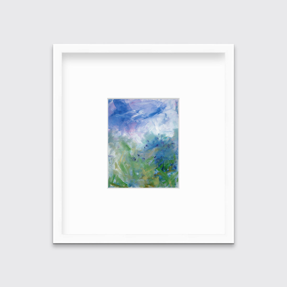A blue, purple and green abstract print in a white frame with a mat hangs on a white wall.