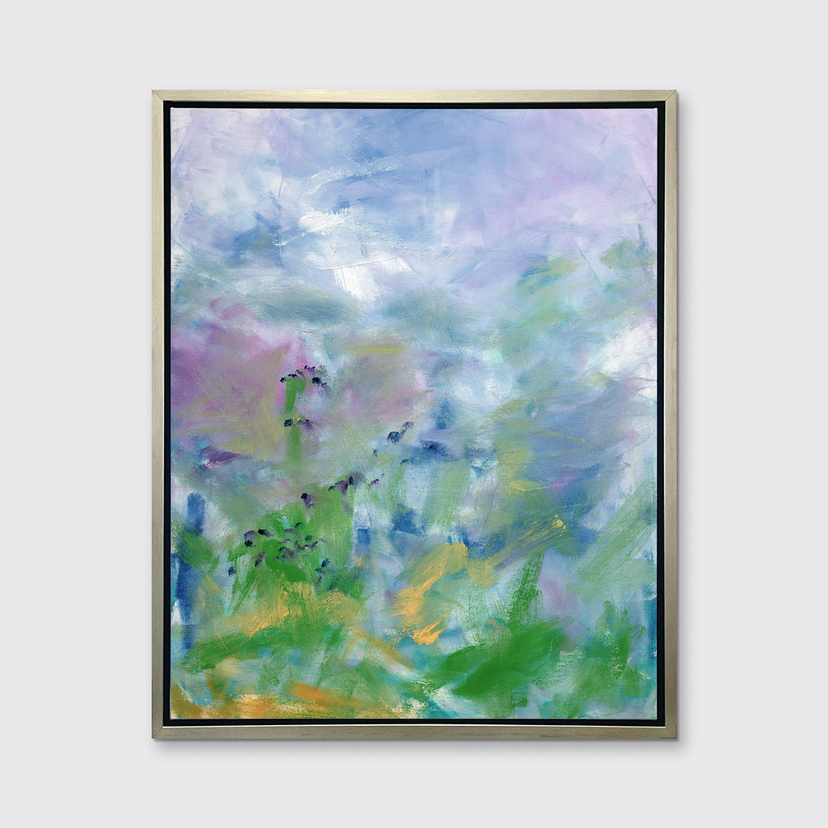 A blue, purple and green abstract print in a silver floater frame hangs on a white wall.