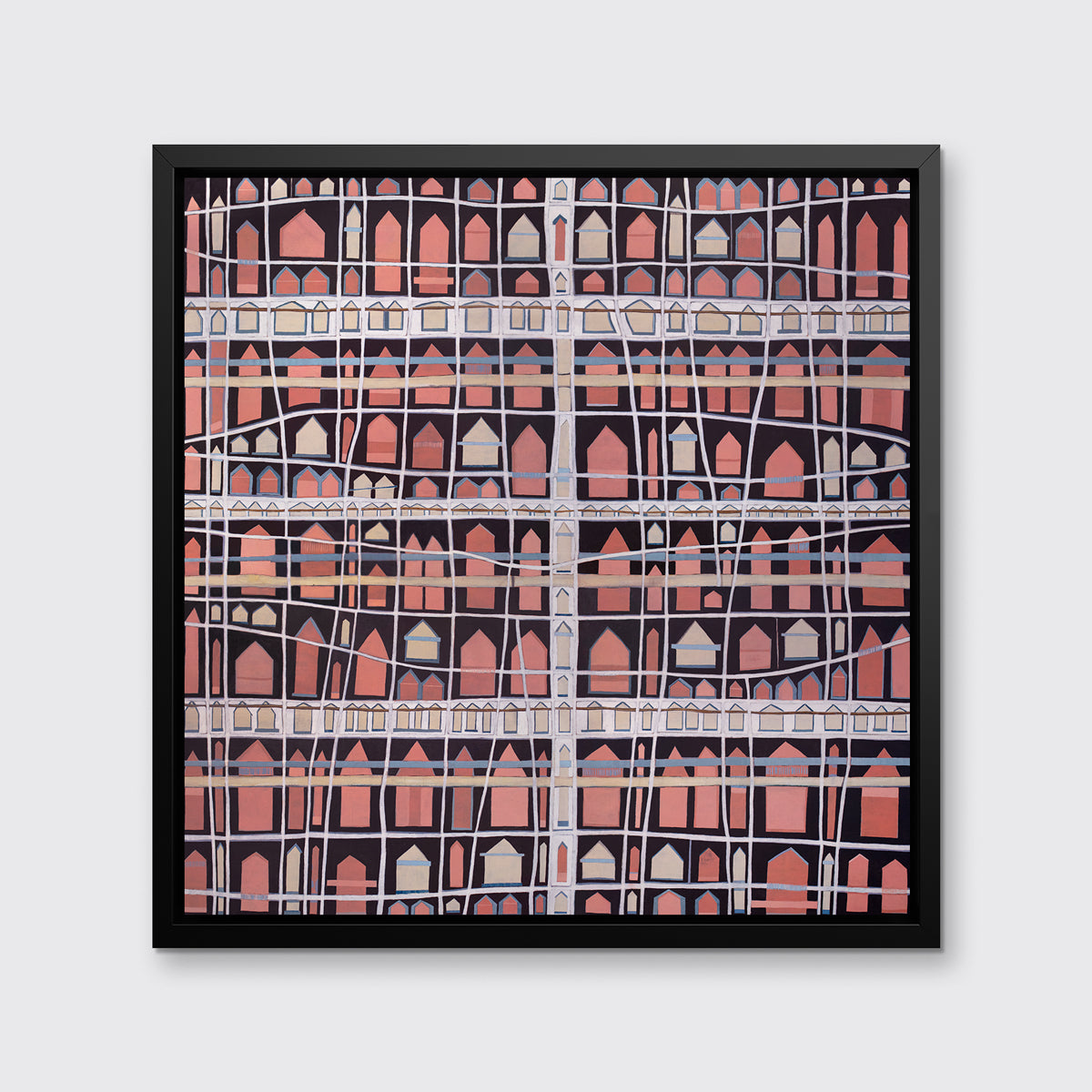 A pink, white and black abstract house print in a black floater frame hangs on a white wall.