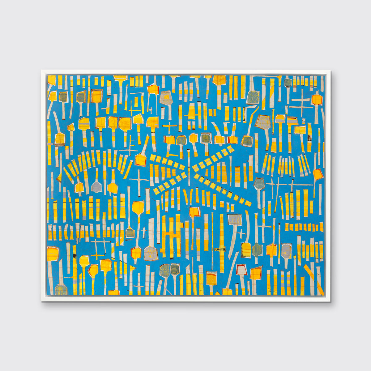 A blue and yellow abstract print in a white floater frame hangs on a white wall.