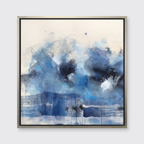 A blue, beige, white and black abstract print in a silver floater frame hangs on a white wall.