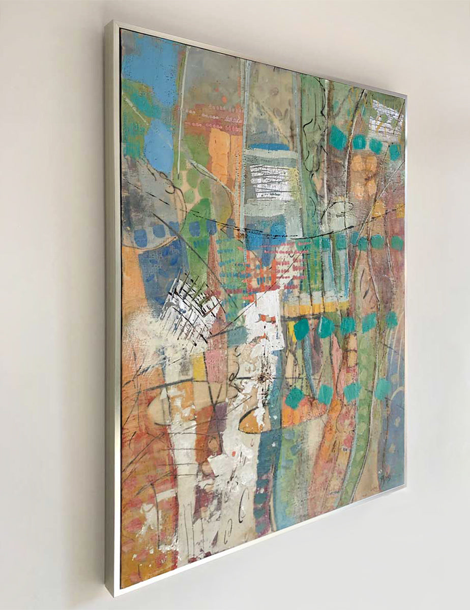 Left-hand side-angle view of a framed multicolored abstract painting by Linda Bigness, hanging on a white wall.