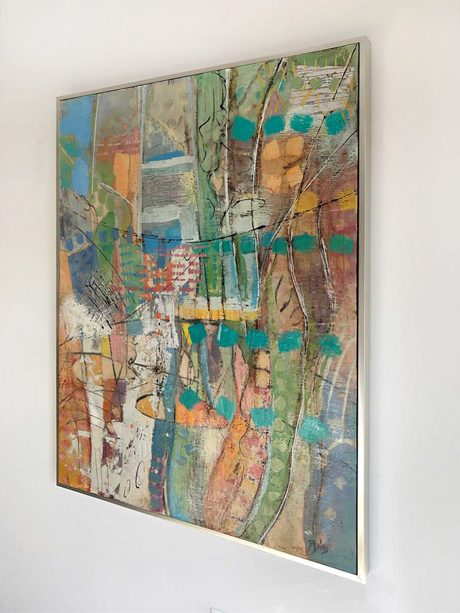 A right-hand side-angle view of a framed multicolored abstract painting by Linda Bigness, hanging on a white wall.