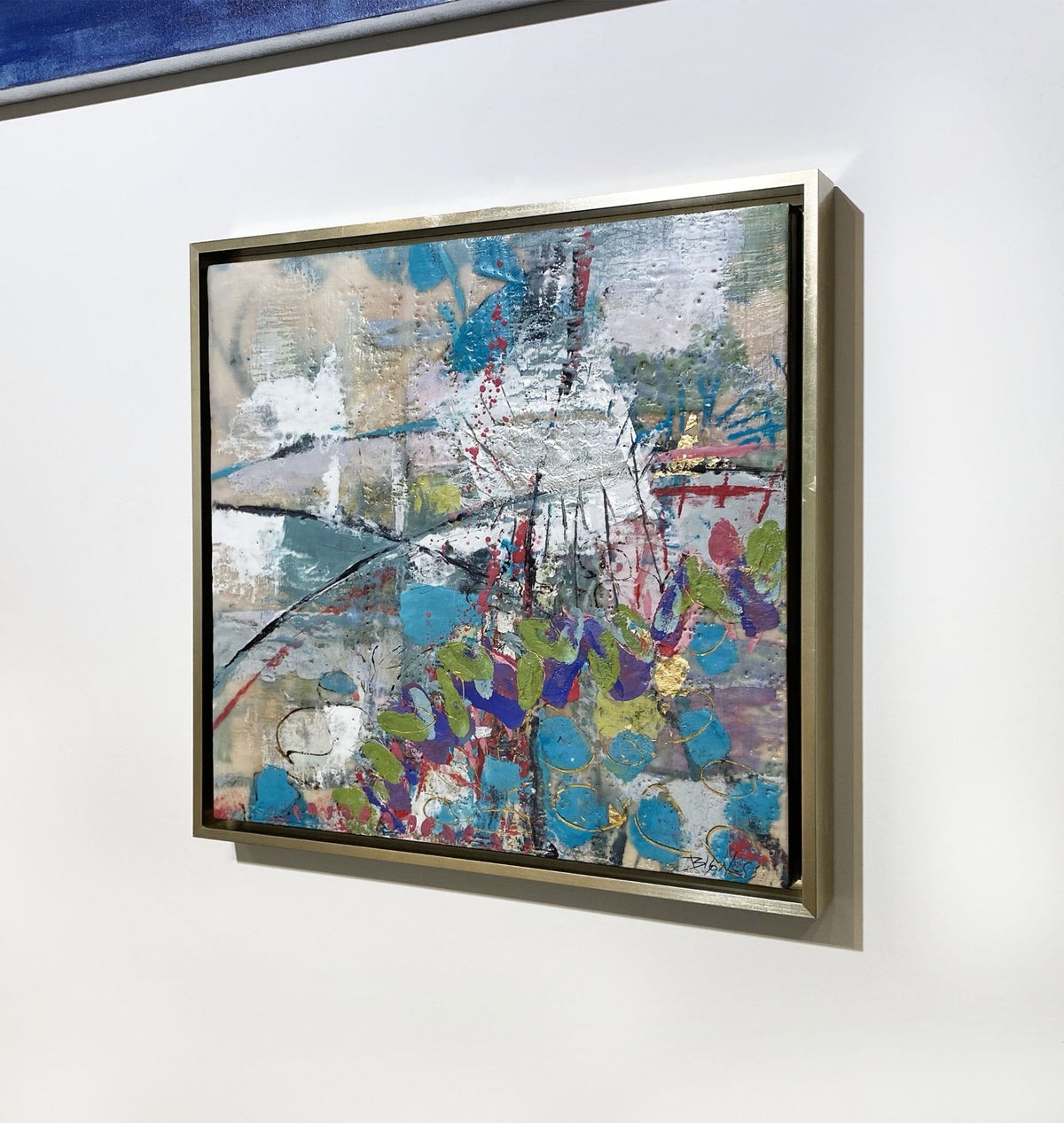 A right-hand side-angle view of an abstract encaustic painting by Linda Bigness, hanging on a white wall.