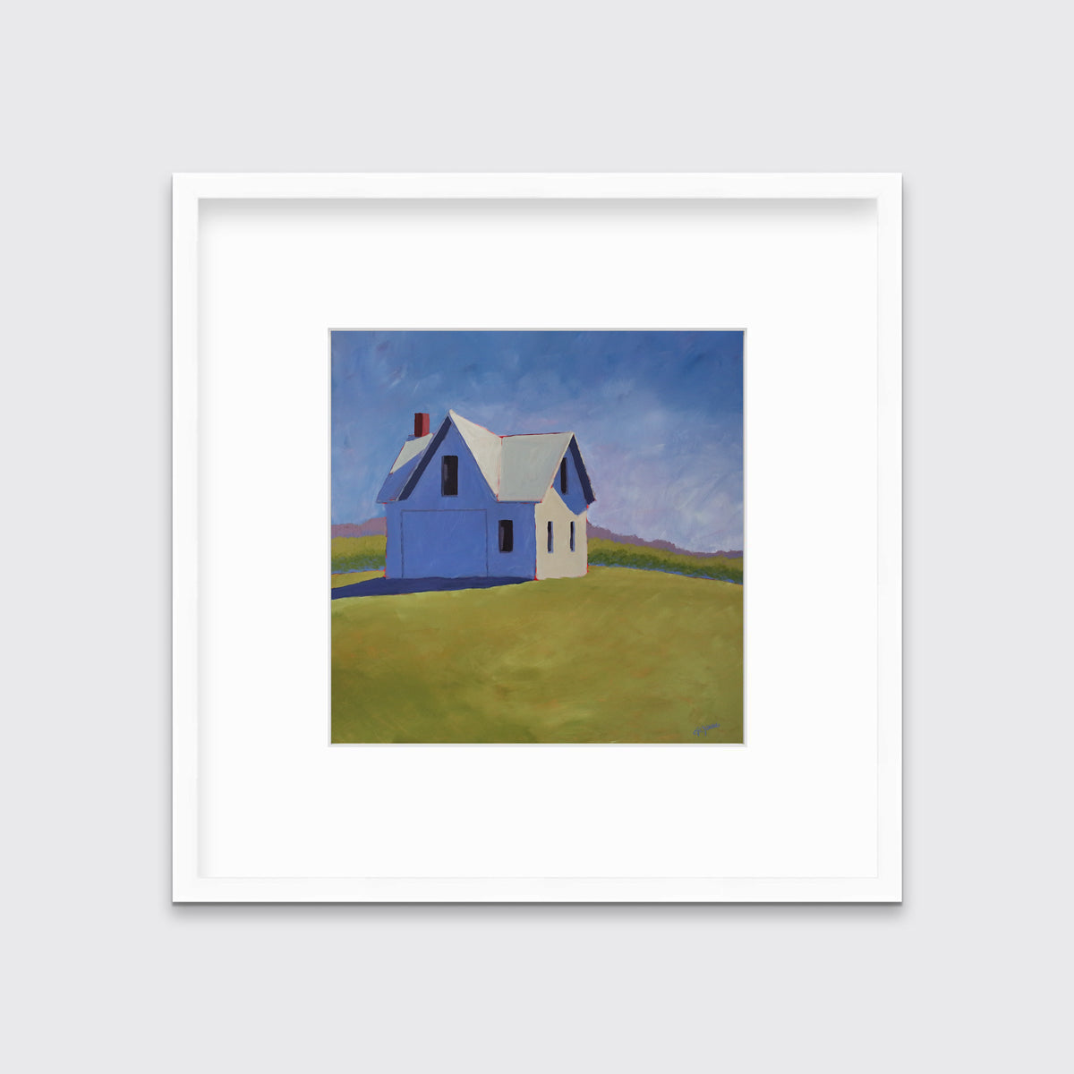 A blue and green contemporary barn print in a white frame with a mat hangs on a white wall.