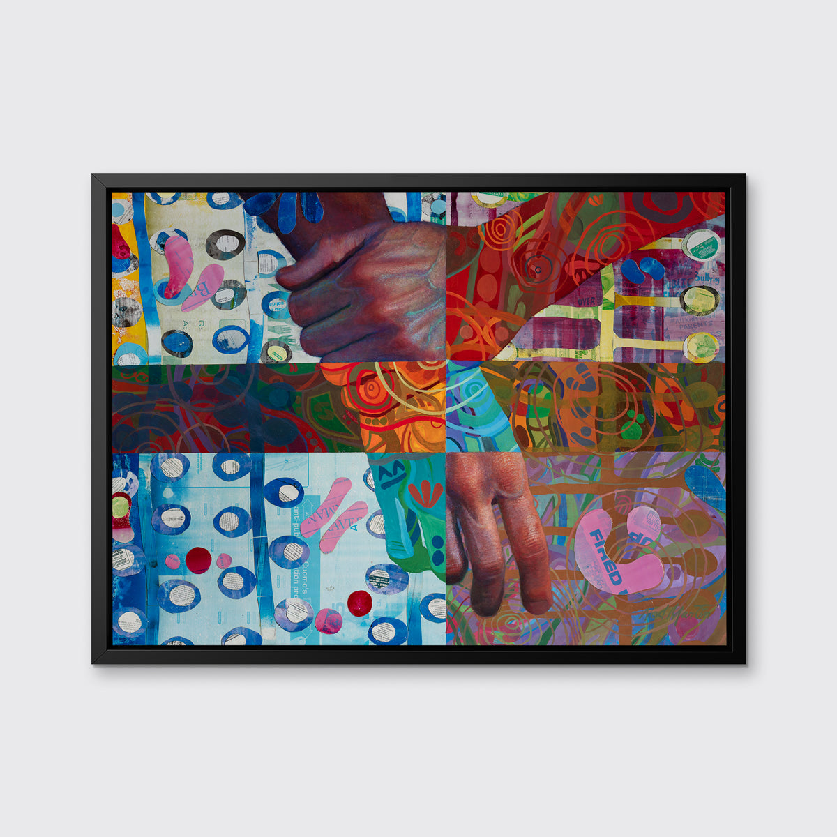 A multicolored abstract print of two hands in a black floater frame hangs on a white wall.