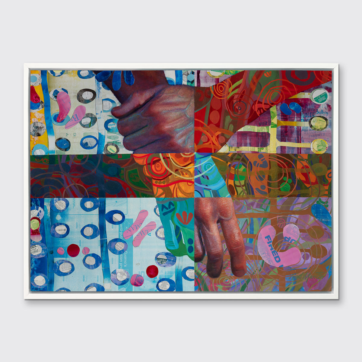 A multicolored abstract print of two hands in a white floater frame hangs on a white wall.