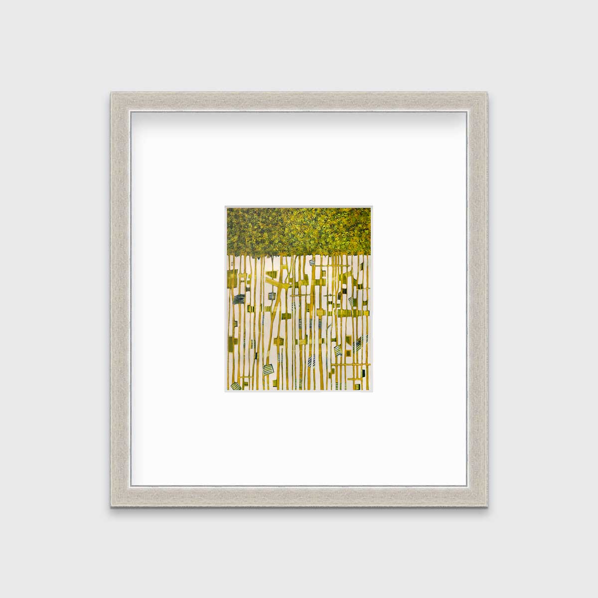 A green, yellow and white abstract print in a silver frame with a mat hangs on a white wall.