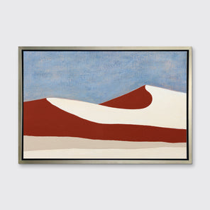 A blue, red and beige abstract landscape print in a silver floater frame hangs on a white wall.