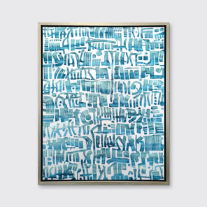 A teal and white abstract shapes print in a silver floater frame hangs on a white wall.