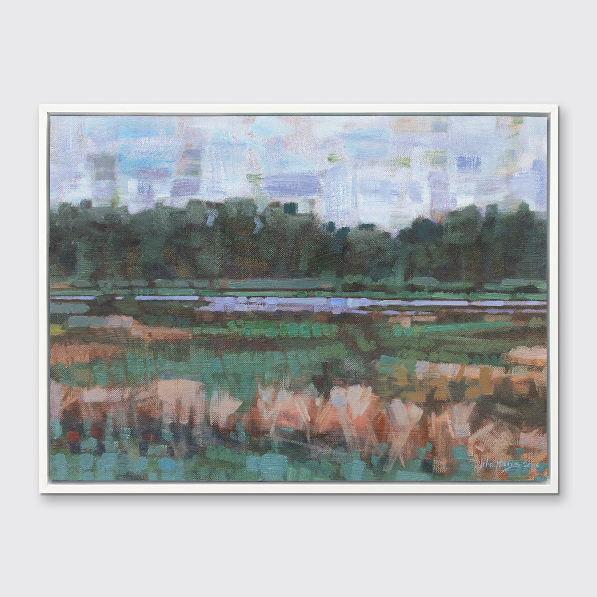 A green, orange and blue abstract landscape print in a white floater frame hangs on a white wall.