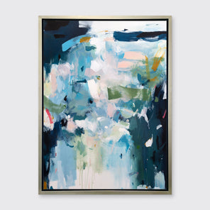 A blue, white and green abstract print in a silver floater frame hangs on a white wall.