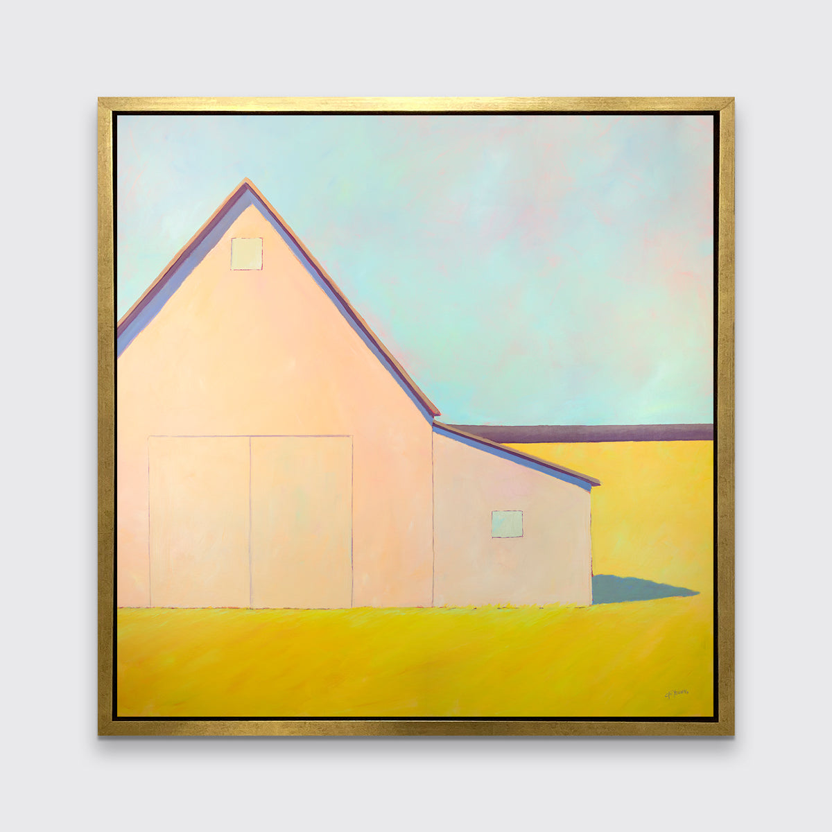 A light blue, coral and deep yellow landscape print of a barn in a gold floater frame hangs on a white wall.