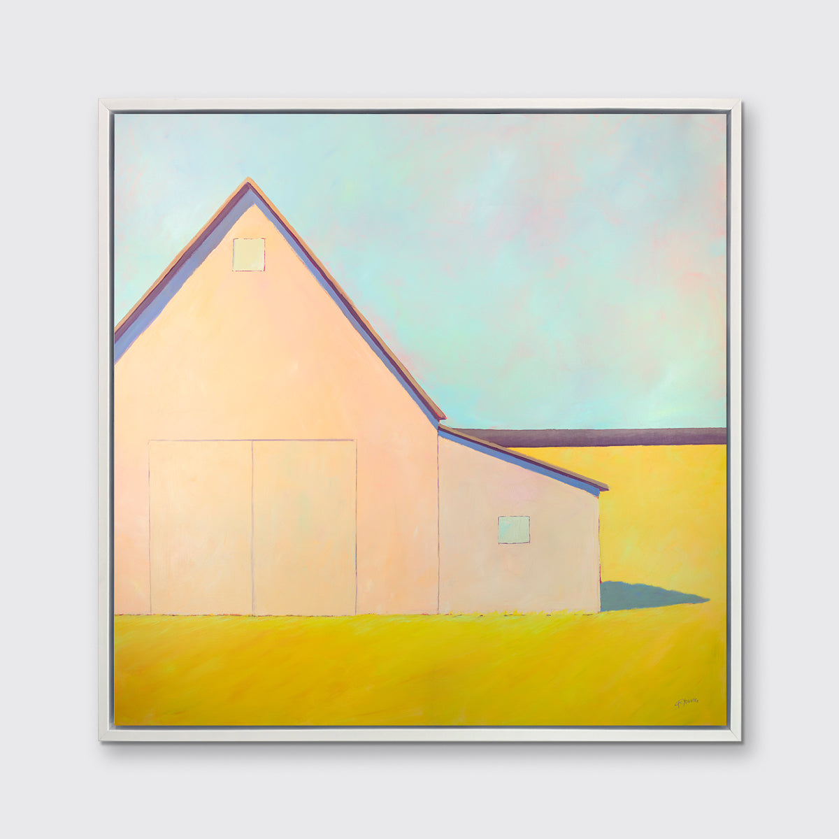 A light blue, coral and deep yellow landscape print of a barn in a white floater frame hangs on a white wall.