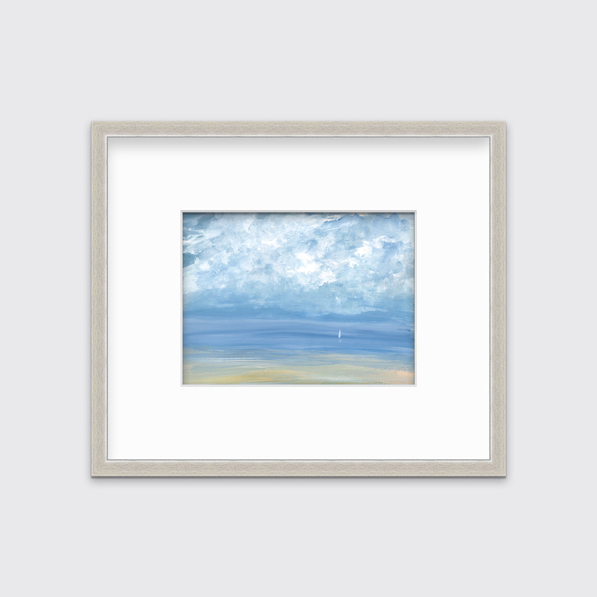 A white, blue and beige abstract seascape print in a silver frame with a mat hangs on a white wall.