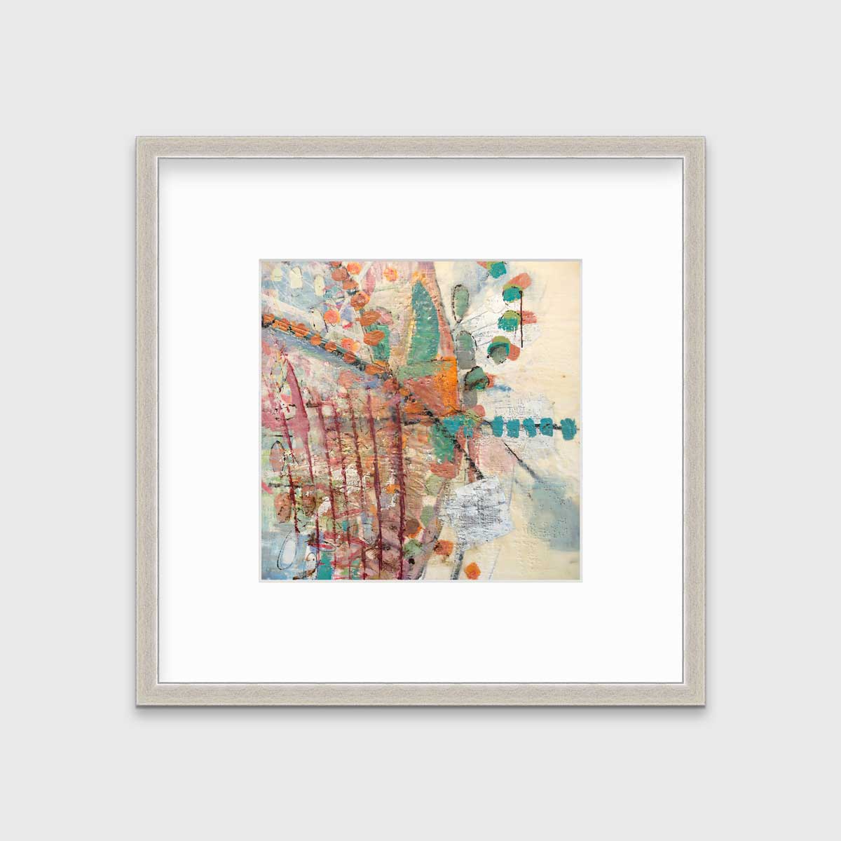A multicolored abstract print in a silver frame with a mat hangs on a white wall.