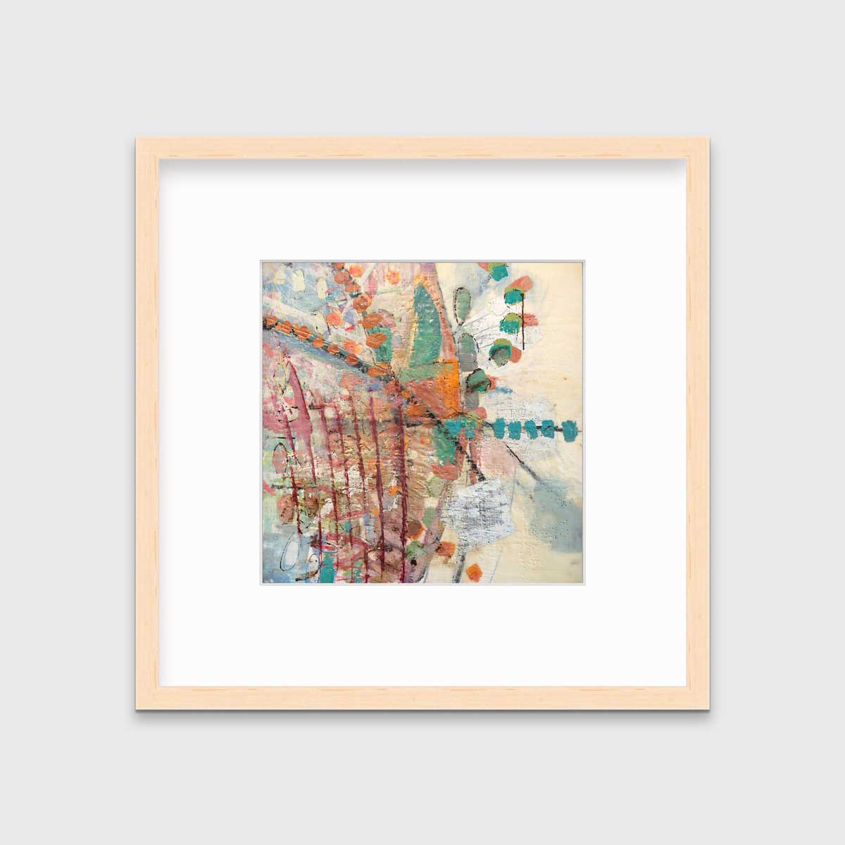 A multicolored abstract print in a natural wood frame with a mat hangs on a white wall.
