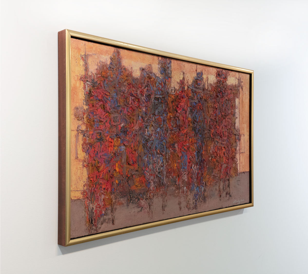 The multicolored and textured painting composed of red and blue brush swirls is seen at an angle. The painting is wired and ready to hang.