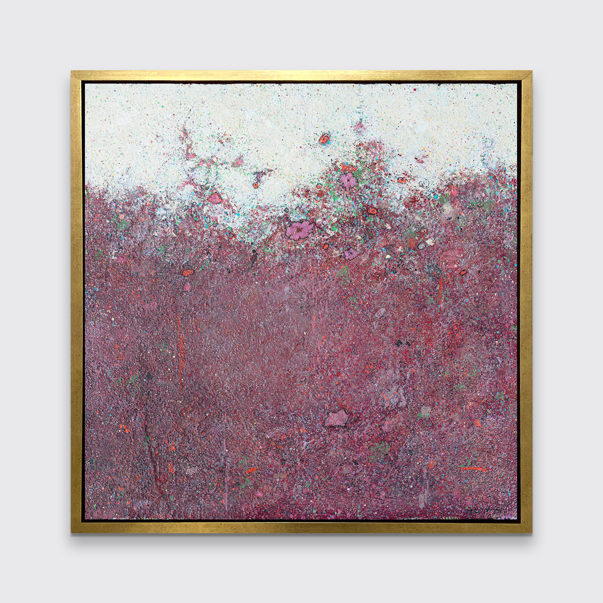 A red abstract landscape print in a gold floater frame hangs on a white wall.