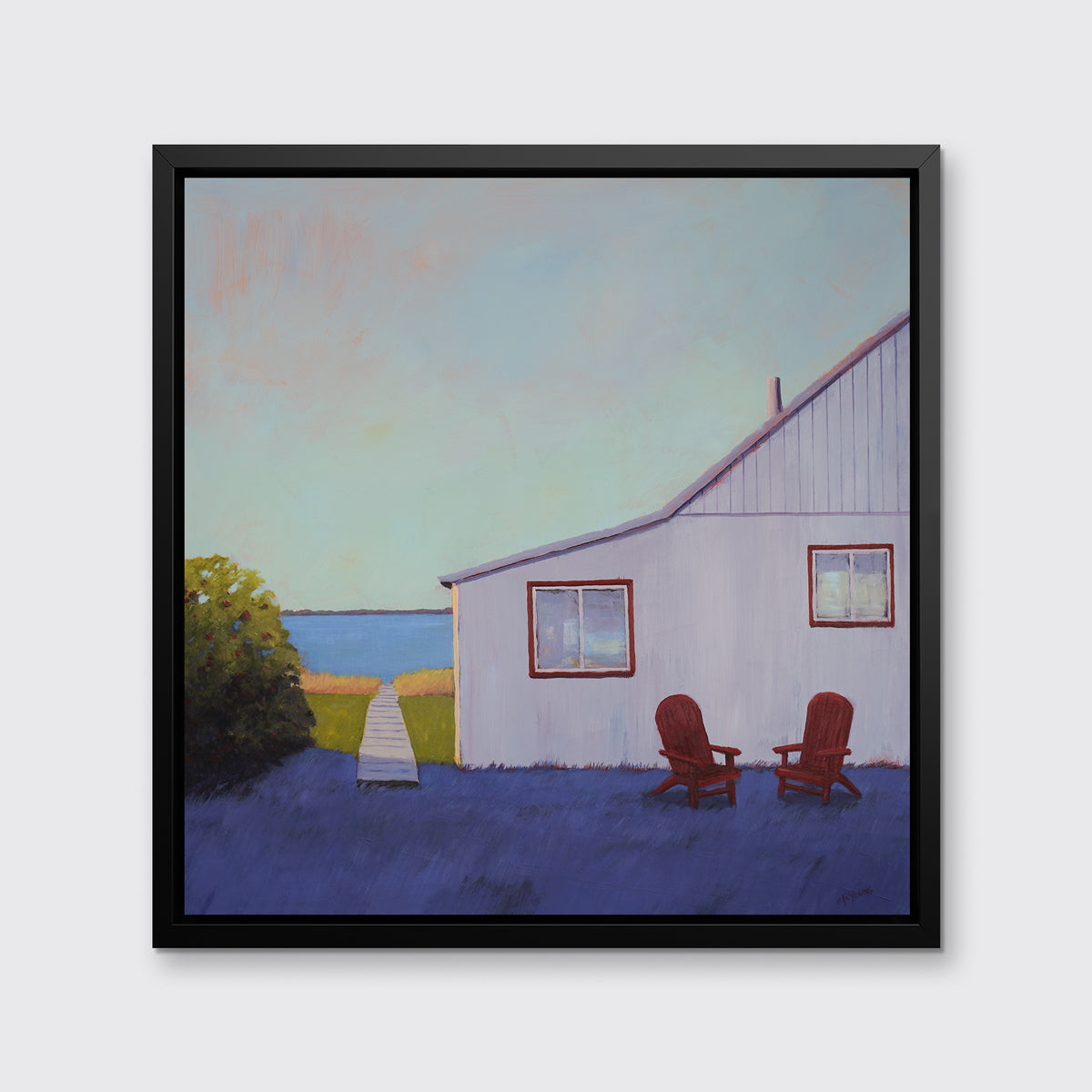 A blue, lavender and light purple contemporary seascape print with a beach house, two red adirondack chairs and a walkway leading to the water in a black floater frame hangs on a white wall.