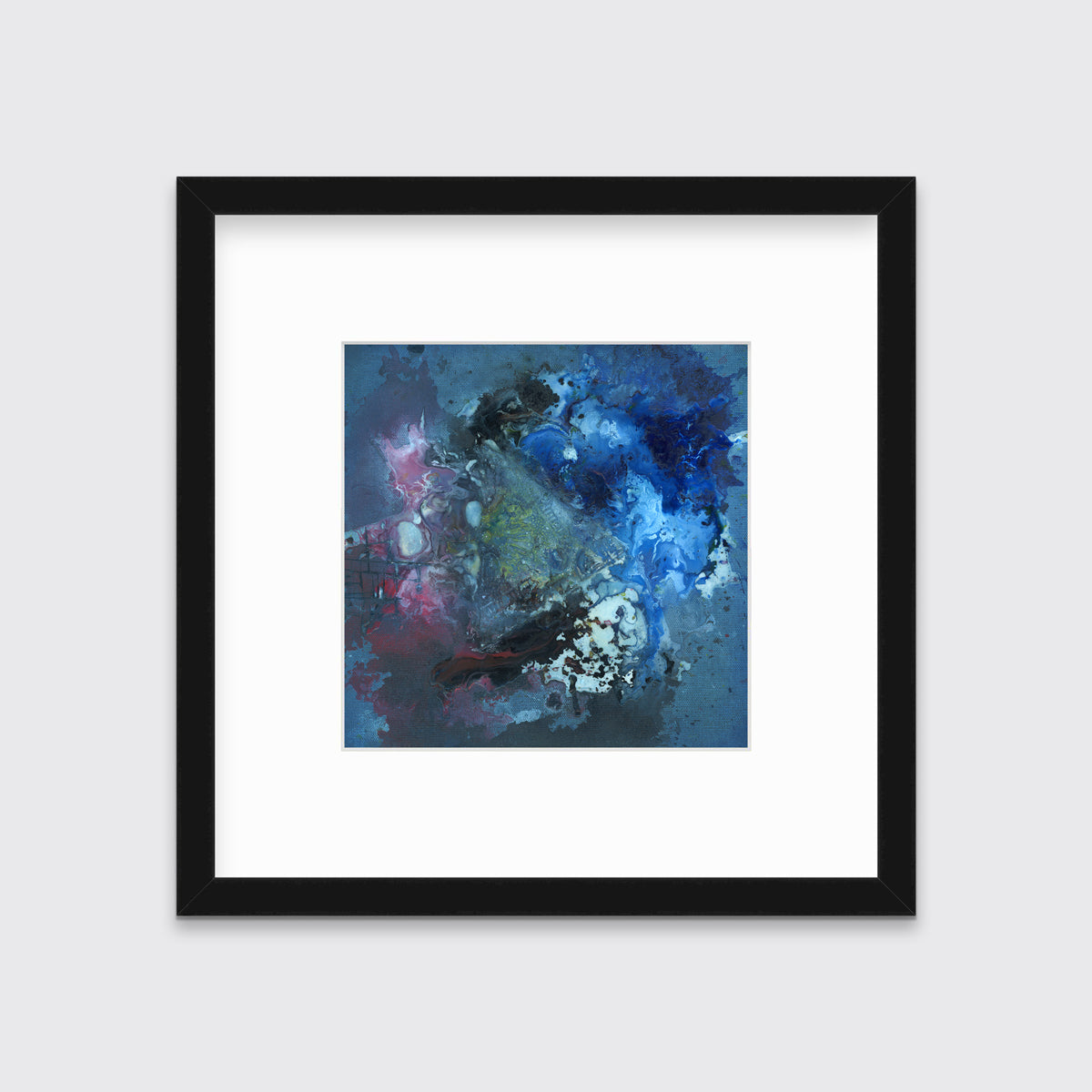 A blue, red, black and green abstract print in a black frame with a mat hangs on a white wall.