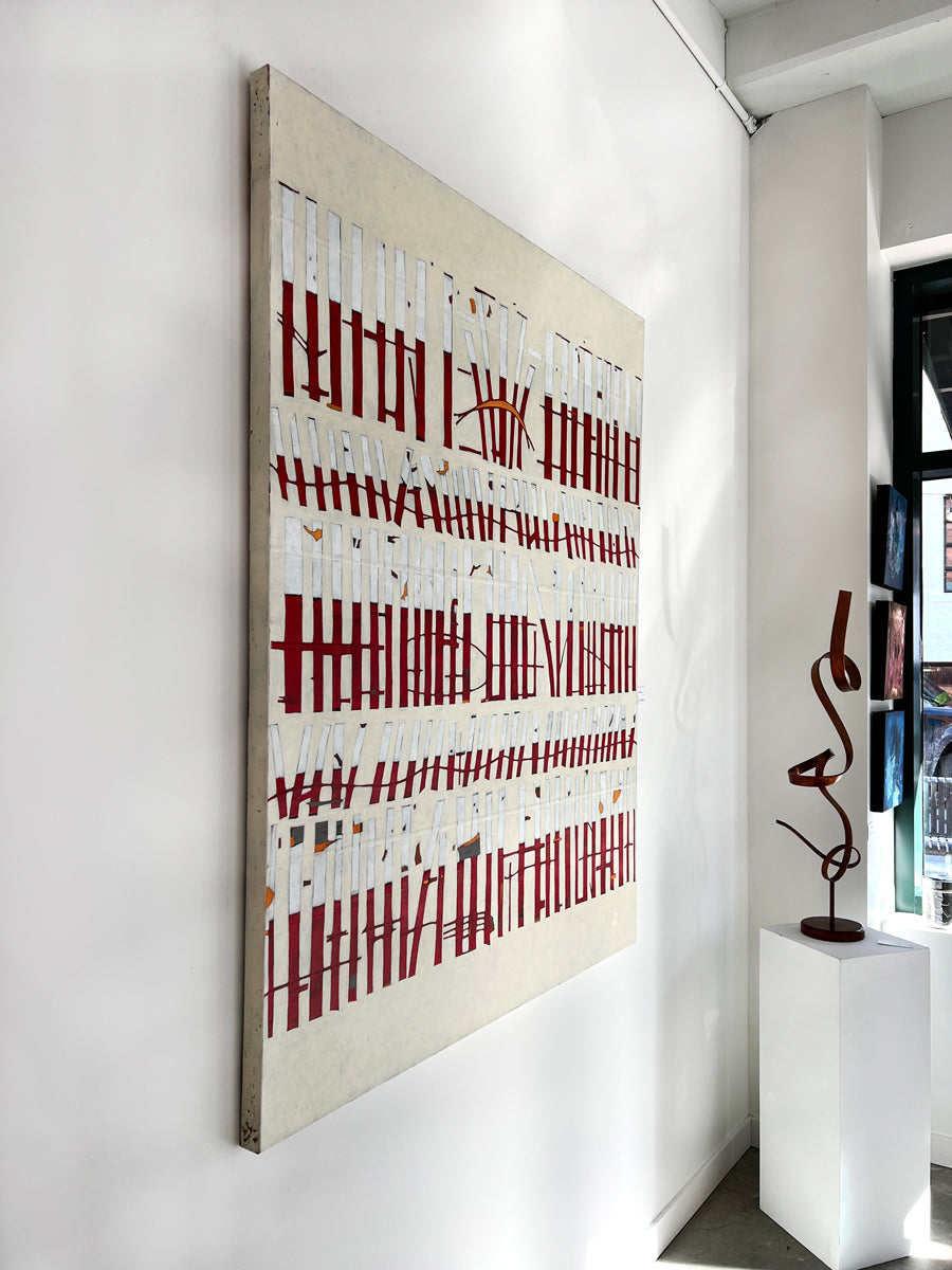 An abstract painting of red and white vertical lines with hints of orange on a beige background hangs on a white wall with a view from the left.