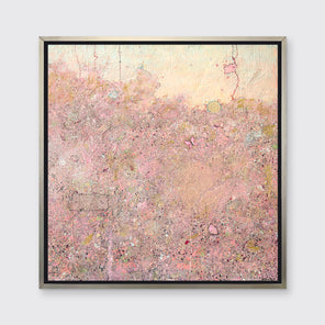 A pink abstract landscape print in a silver floater frame hangs on a white wall.