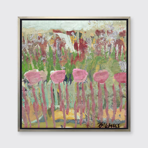 A green, pink and teal abstract floral print in a silver floater frame hangs on a white wall.