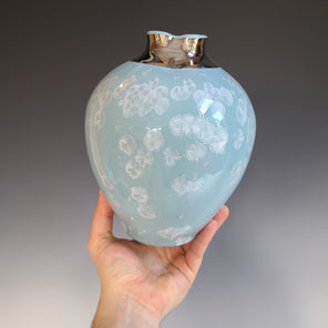 A light blue and crystalline glazed ceramic vessel with a cool-toned gold luster neck.