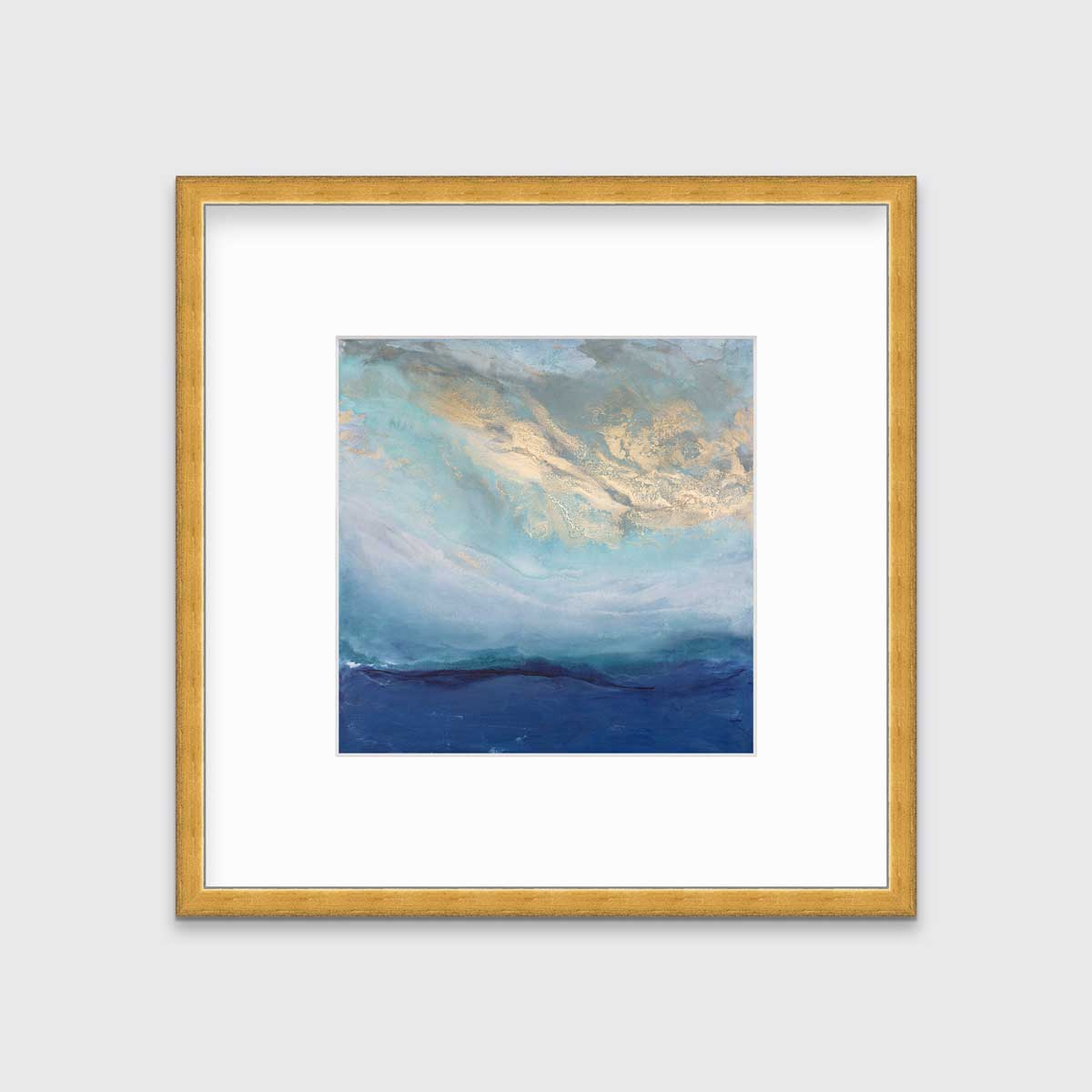 A blue, gold and teal abstract print in a gold frame with a mat hangs on a white wall.
